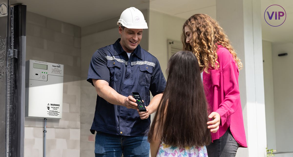 Image of a sub-meter and a technician demonstrating to tenants how the unit works